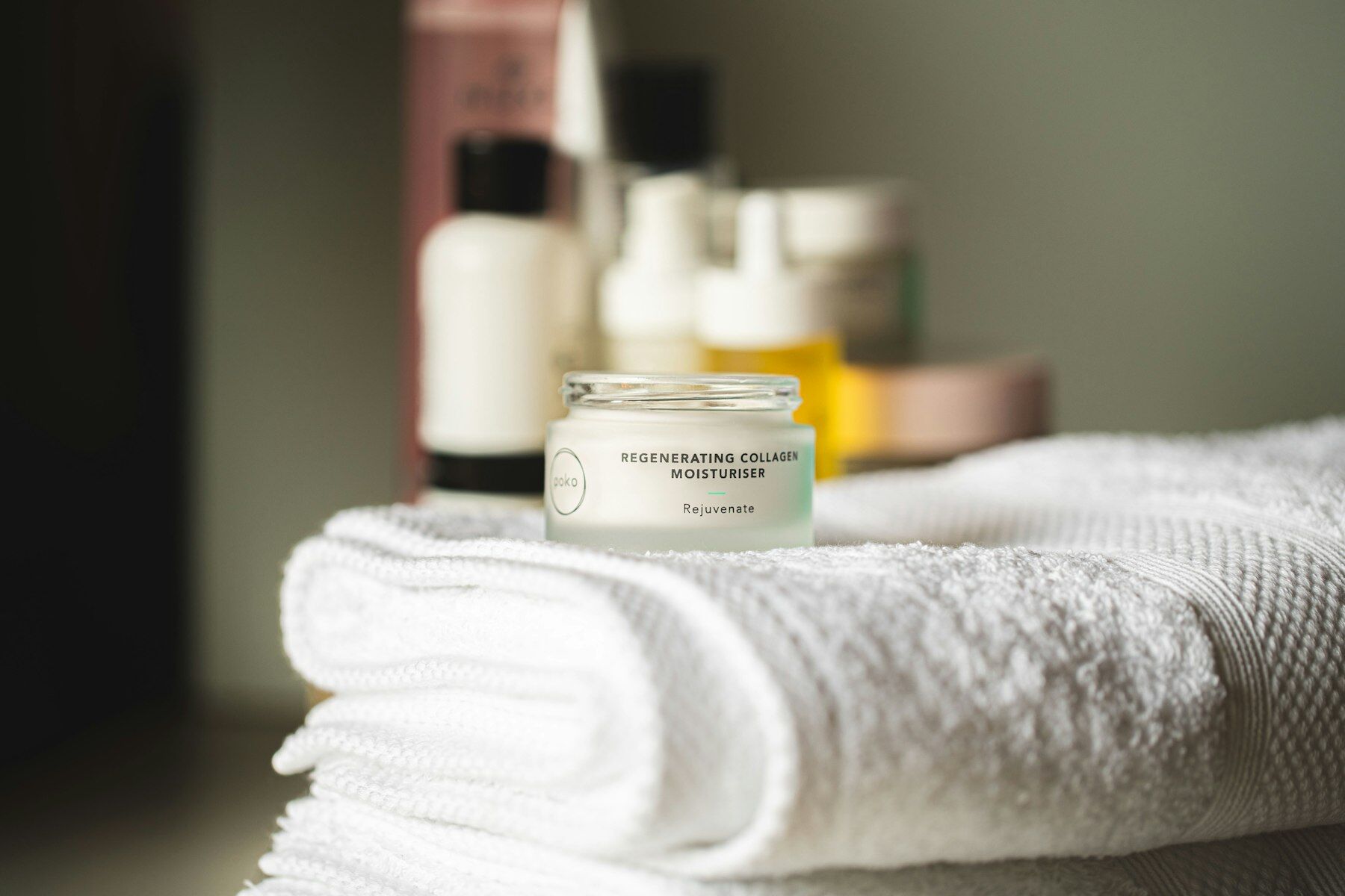 Folded towels with a jar of moisturiser